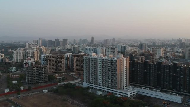 Aerial footage shot in a growing Indian city showcasing architectural buildings as well as new residential apartments.
