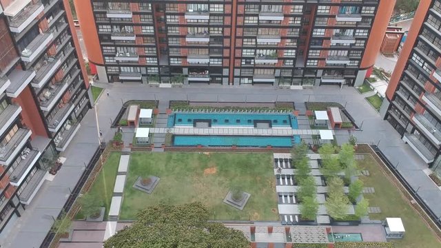 Aerial footage shot in a growing Indian city showcasing architectural buildings as well as new residential apartments.
