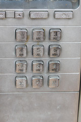 The worn keypad of a payphone is viewed up close, and can still be used today