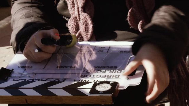 Woman Holding Clapper Board in her Hands. Close-Up. 
