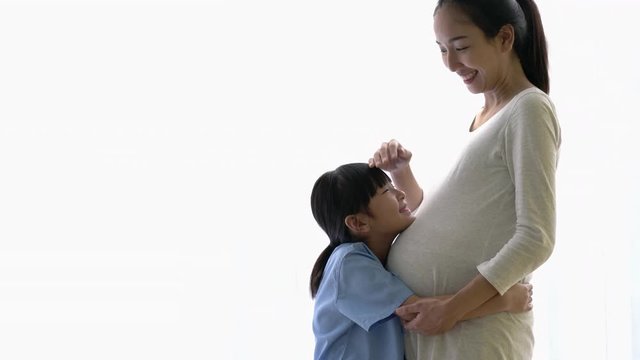 Asian family daughter hug and listening sound flex in pregnant mother belly. Children flex in the stomach. Concept of family, hope and new born.