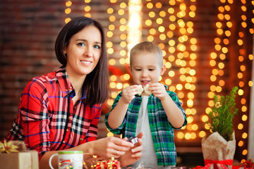 mom and son prepare Christmas cookies for Christmas