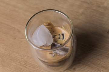 Espresso coffee with heart shaped ice rocks on a wooden background