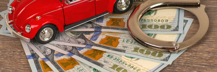 red car and handcuff with 100 dollars banknotes