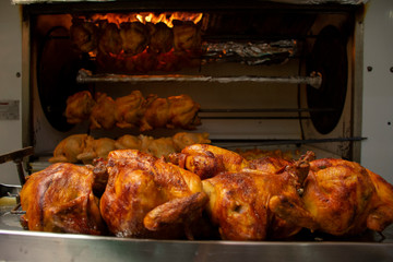 Fototapeta premium Pollo rostizado preparado al fuego de una parrilla de asador profesional