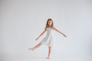 girl in white dress dancing on white background