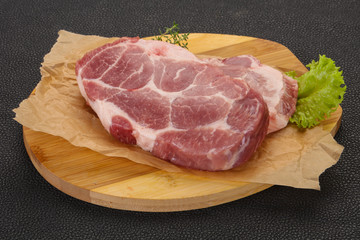 Raw pork steak over wooden board