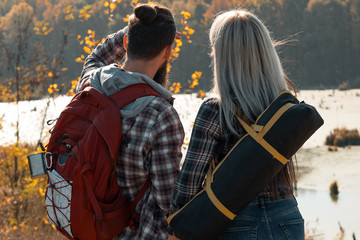 Hiking travel. Back view of couple looking at forest and swamp. Fall nature landscape background.