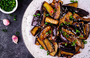 Hot spicy stew eggplant in Korean style with green onion. Aubergine saute. Vegan food. Top view