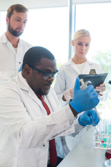 Scientist and students working in lab. Doctor teaching interns to make blood analyzing research....