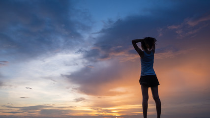 Silhouette of free woman enjoying freedom feeling happy at sunset. Serene relaxing woman in pure happiness