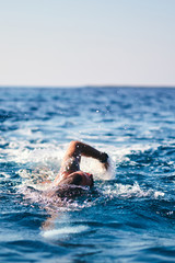 Swimmer training on the open sea / ocean.