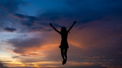 Silhouette of free woman enjoying freedom feeling happy at sunset. Serene relaxing woman in pure happiness