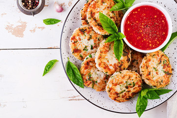 Delicious rice and chicken meat patties with garlic tomato sauce. Top view. Diet food. Copy space