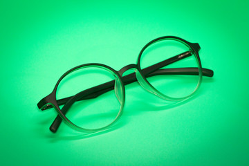 Image of modern fashionable spectacles isolated on green background, Eyewear, Glasses