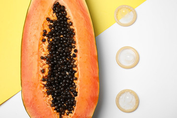 Flat lay composition with condoms and papaya on color background. Erotic concept