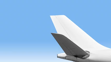 Zelfklevend Fotobehang modern airplane for air travel with plane tail parts isolated on blue sky background closeup crop side view of commercial passenger jet aircraft for business trip flying wide copy space design mockup © vaalaa