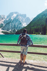 Fototapeta na wymiar man with backpack standing looking on lake in mountains