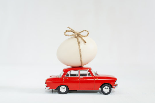 Red Toy Car With Chicken Egg On The Roof