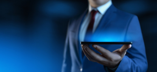 Businessman holding smartphone. Man using phone in office