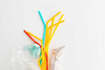 Plastic waste danger ecology concept with garbage  and colorful single use straws, cutlery cups, bottles on white background