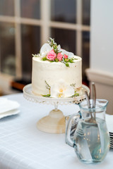 White cream wedding cake with flower decoration on it.