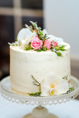 White cream wedding cake with flower decoration on it.