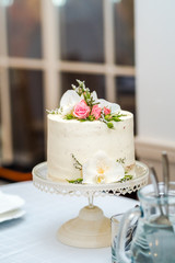 White cream wedding cake with flower decoration on it.