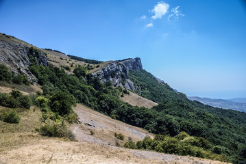 Fototapeta na wymiar The mountains with a cloud overhead.Landscape of mountains and rocks. Green nature of stone mountain. Natural beauty. Nature of Crimea. Ukraine