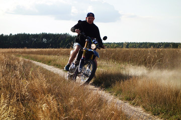 Man riding cross motorbike on country road