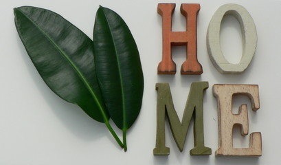 The inscription "HOME" of the wooden letters on a white background.