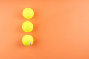 Three tennis balls on orange. Concept