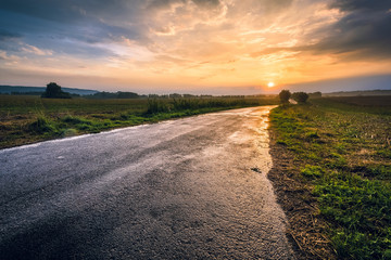 droga po deszczu w stronę zachodzącego słońca © Tomasz