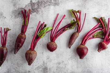Fresh beetroots scattered over a stone background, top view