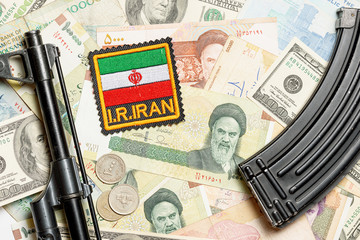 Soviet automaton AK 47 against the backdrop of Iranian money depicting Ruhollah Khomeini and...