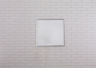 white monitor on white brick wall, white frame