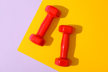 Dumbbells for fitness on two tone background, space for text