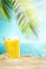 Poster Im Rahmen Table background with orange ice juice in a glass on a wooden table top with beautiful blue sky and ocean and palm tree view. © magdal3na