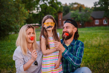 Funny man, woman and child with protruding tongues in rocker style scream.