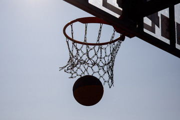 Naklejka premium The ball pierces the net at a basketball game / streetball