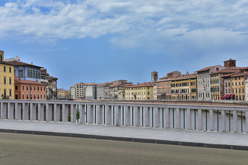 A view from the bridge on the architecture of the city of Pisa in Italy.