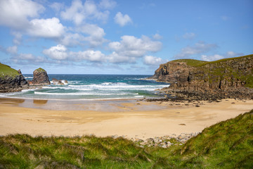 sandy bay with waves crashing onshore on the Isle of Lewis, Outer Hebrides in Scotland on a sunny...