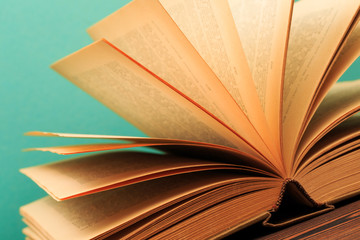 Open book on wooden vintage table blue background .