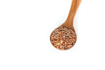 Brown flax seed in spoon on white background.