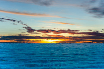 Fototapeta na wymiar Infinity swimming pool with sunset sky vover the ocean.