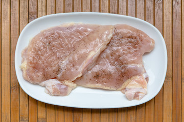Raw chicken, semi-finished product, fillet, chipped with salt and black pepper for frying