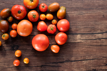Fototapeta na wymiar Ripe fresh organic tomatoes on a brown wooden table.