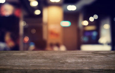 Empty dark wooden table in front of abstract blurred bokeh background of restaurant . can be used for display or montage your products.Mock up for space.