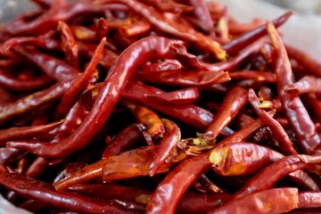 Close up a heap of fresh dry red peppers ( dried chilli ) under natural daylight. Soft focus