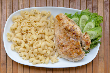 Grilled chicken fillet, pasta and greens